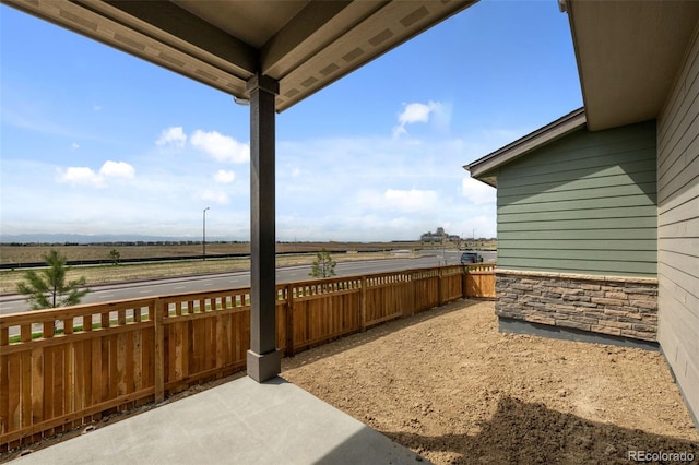 view of patio / terrace featuring a rural view and fence