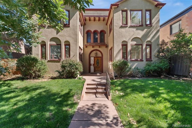 mediterranean / spanish home with stucco siding and a front yard