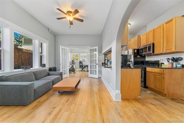 kitchen featuring dark countertops, light wood-style flooring, french doors, and stainless steel appliances