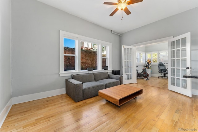 living area with ceiling fan, french doors, baseboards, and hardwood / wood-style flooring