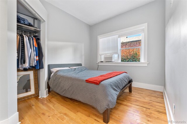 bedroom featuring a closet, baseboards, and hardwood / wood-style flooring