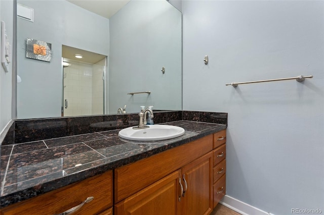 full bathroom featuring vanity, a shower stall, and baseboards