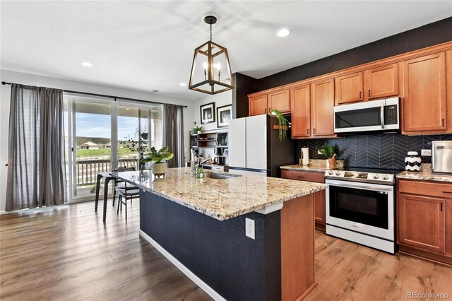 3699 Makley Cir, Castle Rock, CO 80104 - kitchen featuring stainless steel microwave, range with electric stovetop, freestanding refrigerator, a sink, and decorative backsplash
