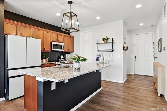 3699 Makley Cir, Castle Rock, CO 80104 - kitchen with stainless steel appliances, baseboards, wood finished floors, a center island with sink, and a sink