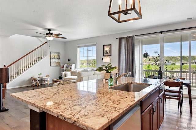 3699 Makley Cir, Castle Rock, CO 80104 - kitchen featuring a sink, dishwasher, a kitchen island with sink, light wood-style flooring, and a ceiling fan