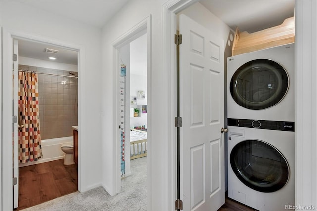 3699 Makley Cir, Castle Rock, CO 80104 - laundry room featuring stacked washer and clothes dryer, baseboards, and wood finished floors