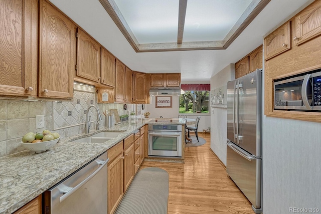 30 Eagle Dr, Littleton, CO 80123 - kitchen with appliances with stainless steel finishes, a sink, light wood-style flooring, backsplash, and light stone counters
