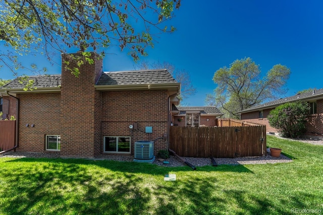 30 Eagle Dr, Littleton, CO 80123 - back of property featuring a chimney, brick siding, central air condition unit, and a shingled roof