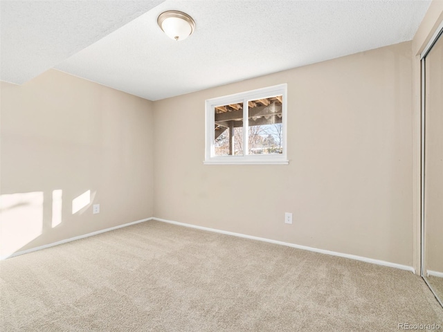 carpeted spare room with a textured ceiling