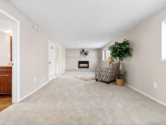 living area featuring a textured ceiling, light carpet, and a fireplace