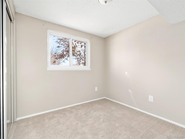 unfurnished bedroom featuring light colored carpet and a textured ceiling