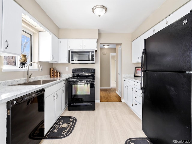 kitchen with sink, white cabinetry, and black appliances