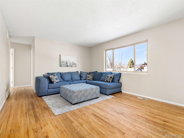 living room featuring light hardwood / wood-style floors and a textured ceiling