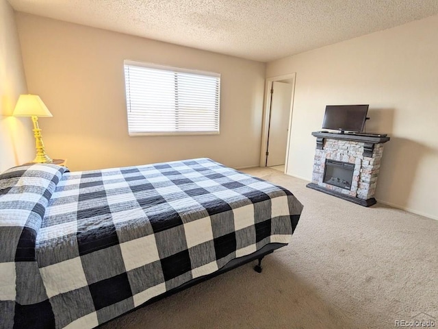 bedroom with light carpet, a fireplace, and a textured ceiling