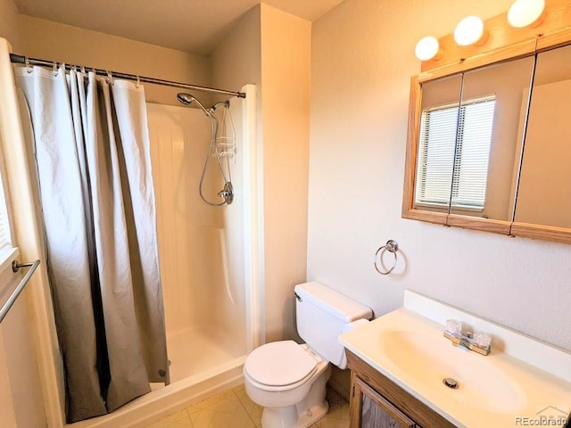 bathroom featuring tile patterned floors, vanity, toilet, and walk in shower