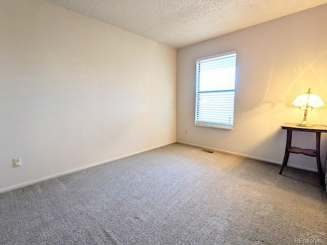 carpeted spare room with a textured ceiling