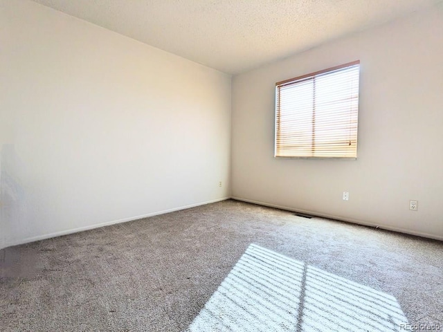 carpeted spare room featuring a textured ceiling