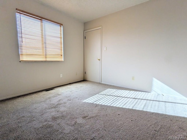 carpeted spare room with a textured ceiling