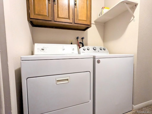 washroom with cabinets and washing machine and clothes dryer