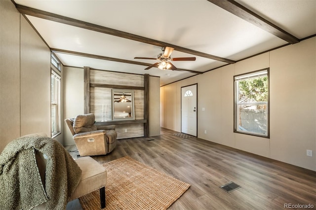 living room with hardwood / wood-style flooring, ceiling fan, and beam ceiling