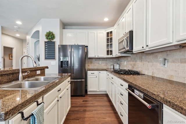 kitchen with appliances with stainless steel finishes, white cabinets, sink, and dark wood-type flooring