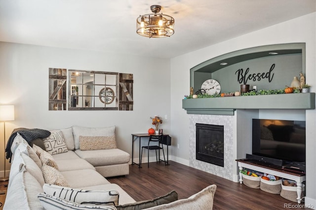 living room with a tile fireplace and dark hardwood / wood-style flooring