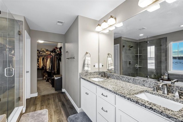 bathroom featuring a shower with door, hardwood / wood-style flooring, and vanity