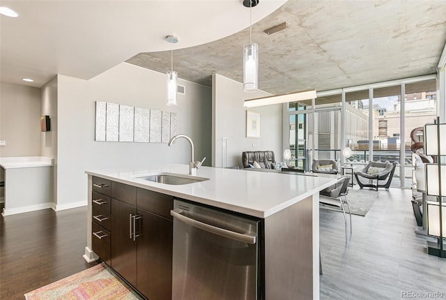 891 14th St Unit 1408, Denver, CO 80202 - kitchen featuring stainless steel dishwasher, wood finished floors, light countertops, decorative light fixtures, and an island with sink