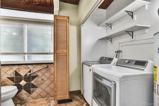 clothes washing area featuring tile patterned flooring and washer and dryer