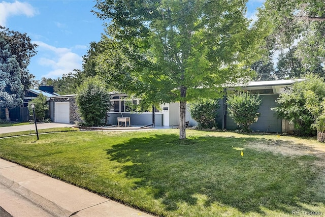 obstructed view of property featuring a garage and a front yard