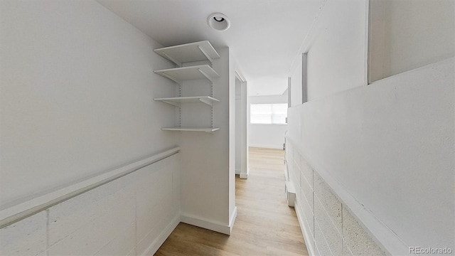 spacious closet with light hardwood / wood-style flooring