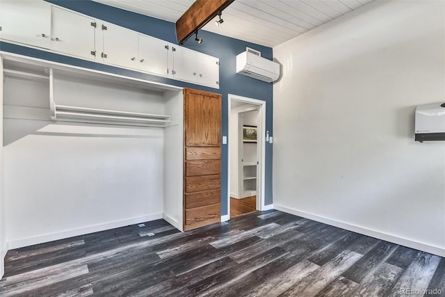 interior space featuring beam ceiling, an AC wall unit, dark hardwood / wood-style flooring, and a closet