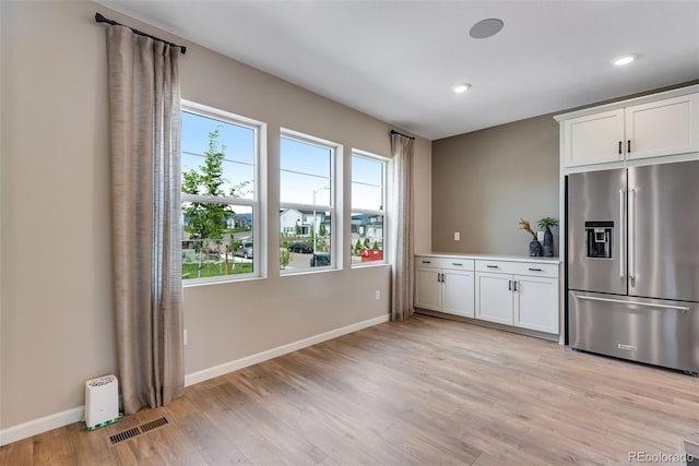 kitchen with white cabinetry, high quality fridge, and light hardwood / wood-style floors