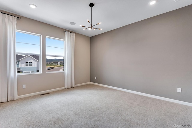 unfurnished room with carpet floors and a chandelier