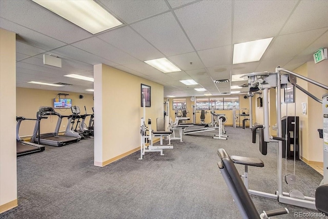 workout area featuring baseboards, a drop ceiling, and carpet flooring