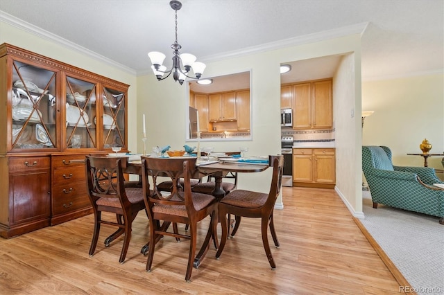 dining room with an inviting chandelier, crown molding, and light hardwood / wood-style flooring