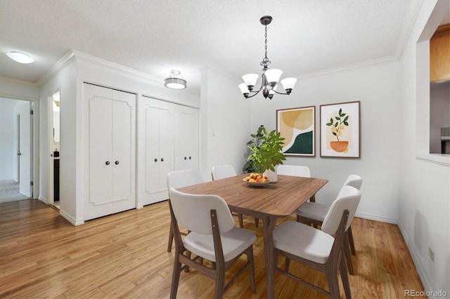 660 S Alton Way Unit 3B, Denver, CO 80247 - dining space featuring ornamental molding, a chandelier, light wood-type flooring, a textured ceiling, and baseboards