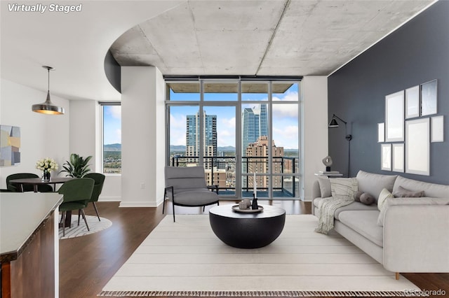 living room featuring floor to ceiling windows, dark wood-type flooring, and plenty of natural light