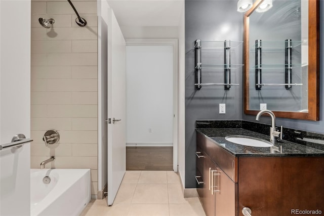 bathroom featuring tile patterned floors, tiled shower / bath, and vanity