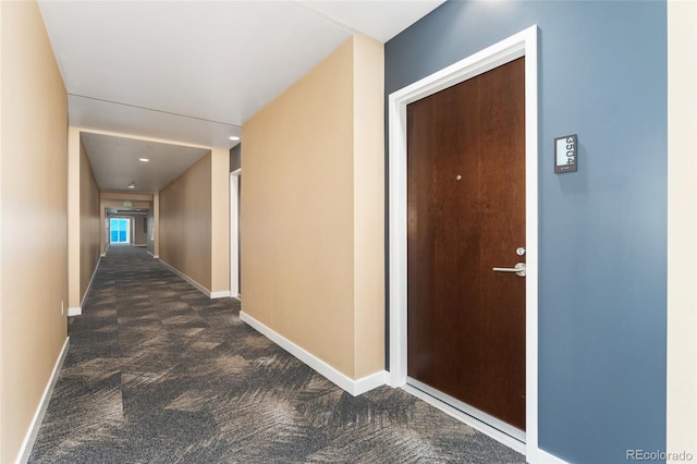 hallway featuring dark colored carpet