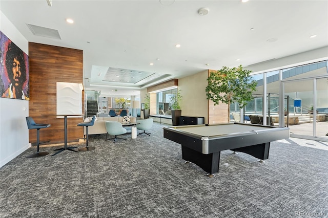 rec room with wooden walls, pool table, a tray ceiling, and carpet flooring