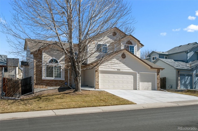 traditional home featuring a garage, driveway, and brick siding