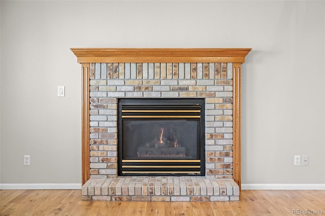room details with a fireplace, wood finished floors, and baseboards