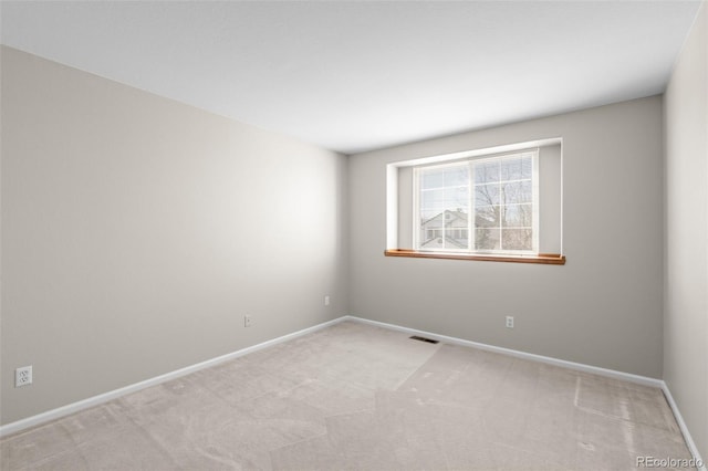 empty room with visible vents, light carpet, and baseboards