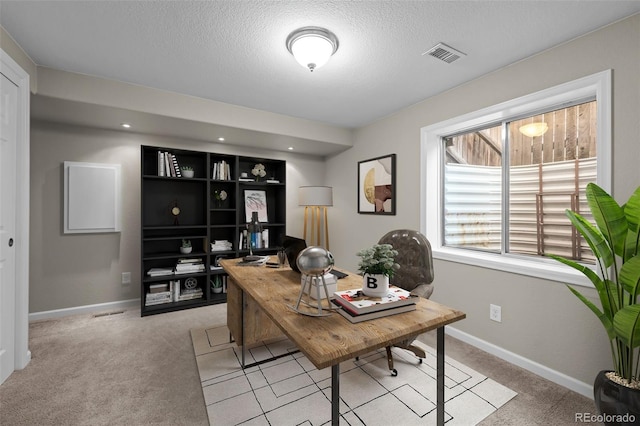 office space with light carpet, baseboards, visible vents, and a textured ceiling