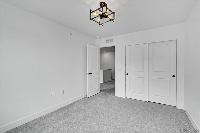 8530 W 52nd Ave Unit A1, Arvada, CO 80002 - unfurnished bedroom featuring carpet, a chandelier, baseboards, and a closet