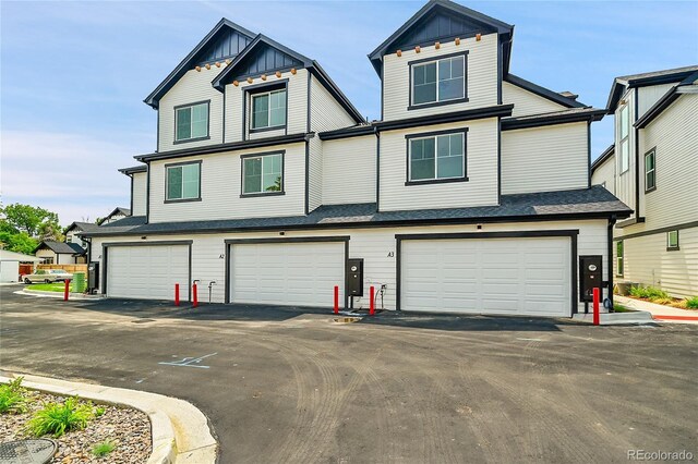 8530 W 52nd Ave Unit A1, Arvada, CO 80002 - view of front of property featuring a garage, board and batten siding, and driveway