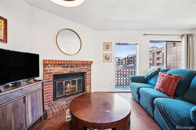 living area featuring a textured ceiling, hardwood / wood-style floors, and a fireplace