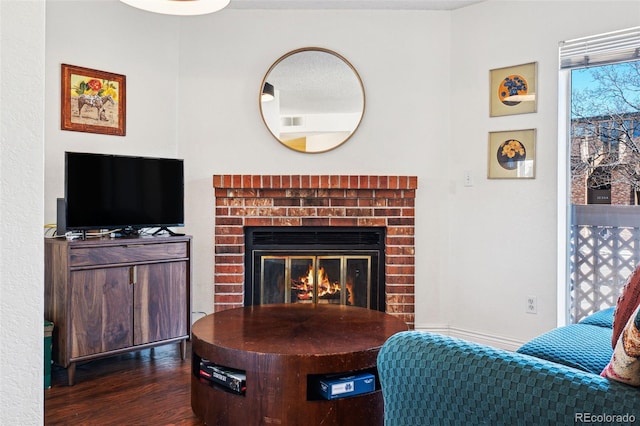 living room with dark wood-style floors and a fireplace