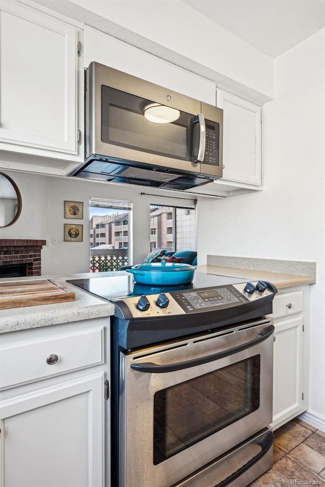 kitchen featuring white cabinetry, stainless steel appliances, and light countertops